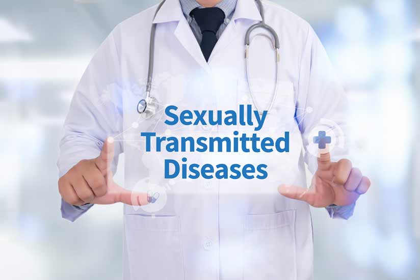 An experienced male doctor shows us a sign on which the sexually transmitted disease is written-std free check in at fitzroy north doctors-mixed-bulk-bill-gp-clinic-melbourne